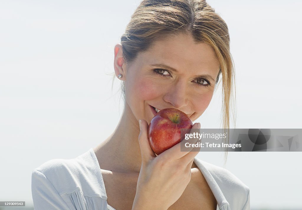 USA, New Jersey, Jersey City, Portrait of woman eating apple