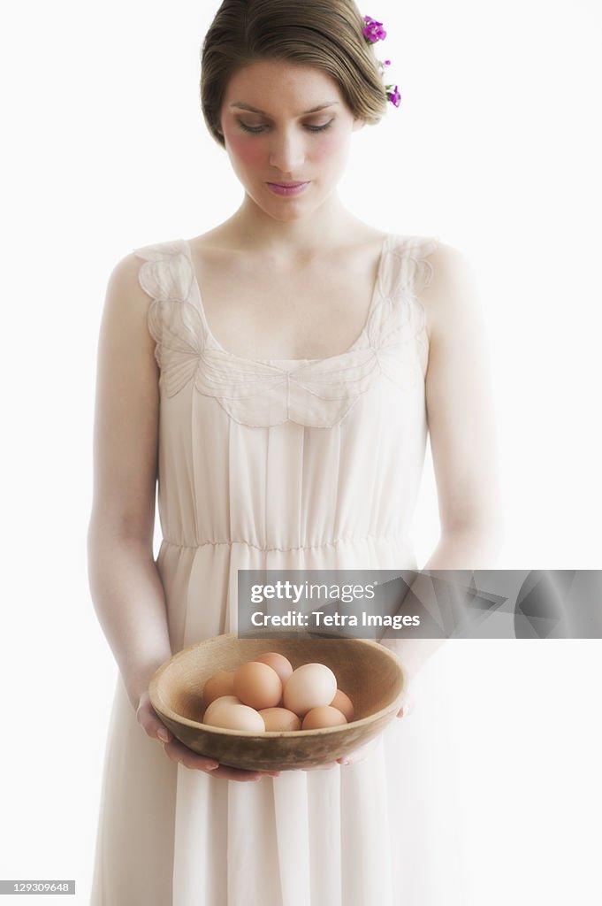 Young woman carrying basket of eggs