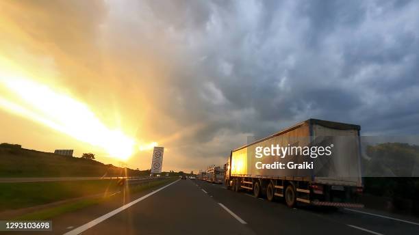car point of view at the sunset - truck highway stock-fotos und bilder