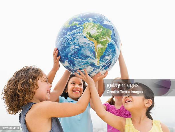 usa, new jersey, jersey city, girls (6-9) holding globe - world children day stock pictures, royalty-free photos & images