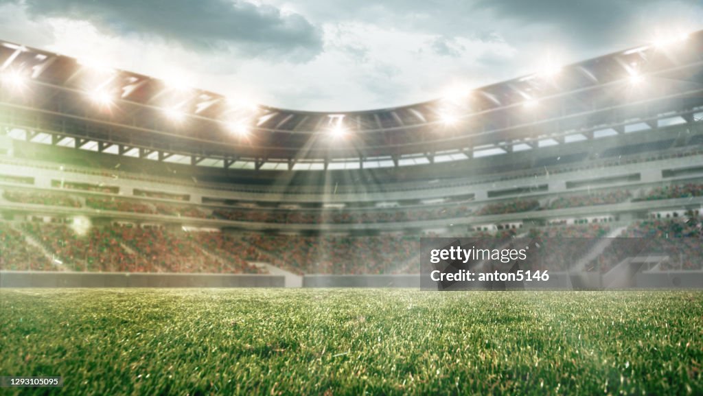 Fußballplatz mit Beleuchtung, grünem Gras und bewölktem Himmel, Hintergrund für Design oder Werbung