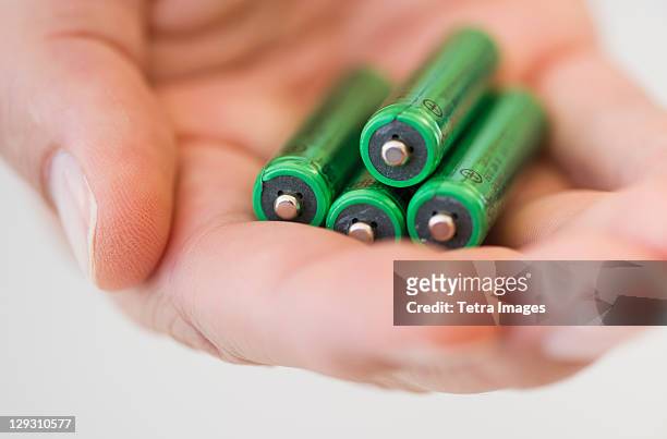 hand holding batteries - batteries stock pictures, royalty-free photos & images