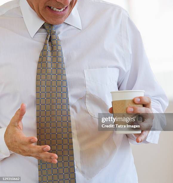 businessman spilling coffee on shirt - oberteil stock-fotos und bilder