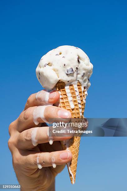 usa, new jersey, jersey city, hand holding melting ice cream - melting stock-fotos und bilder