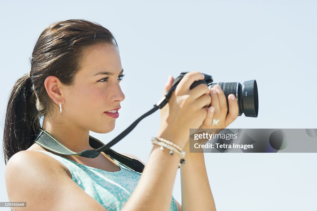 USA, New Jersey, Jersey City, Portrait of young woman taking pictures with camera