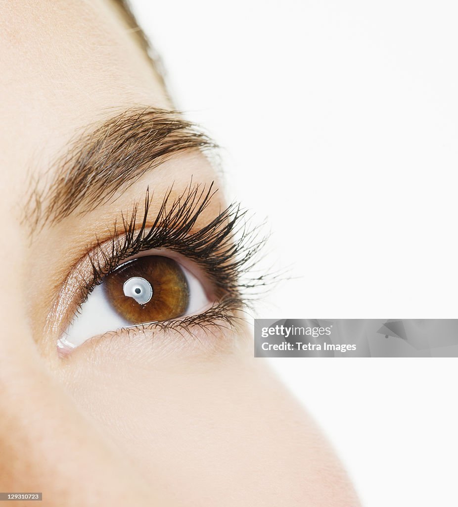 Studio shot of young woman, close-up of eye