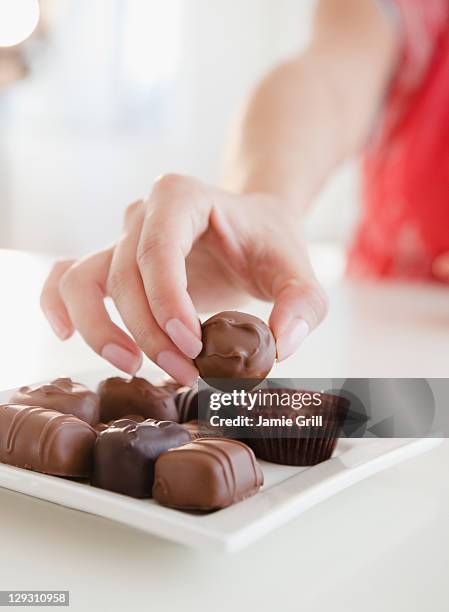 usa, new jersey, jersey city, woman taking praline - praline stock pictures, royalty-free photos & images