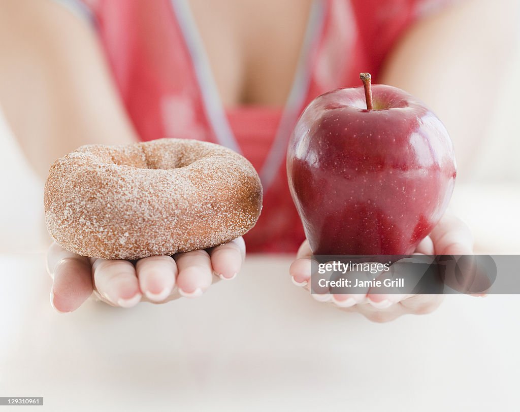 USA, New Jersey, Jersey City, Close up of woman's hands holding donut and apple