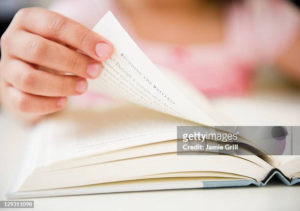 usa, new jersey, jersey city, close up of girl's (8-9) hand turning pages - sfogliare libro foto e immagini stock