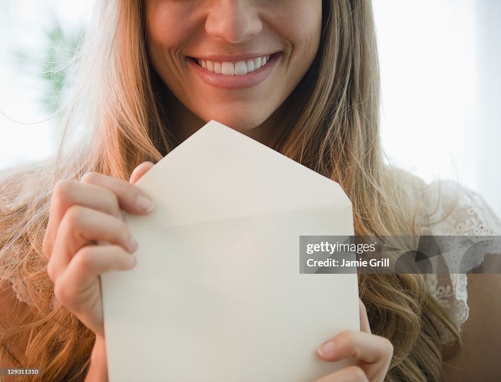 USA, New Jersey, Jersey City, Portrait of blonde woman holding envelope