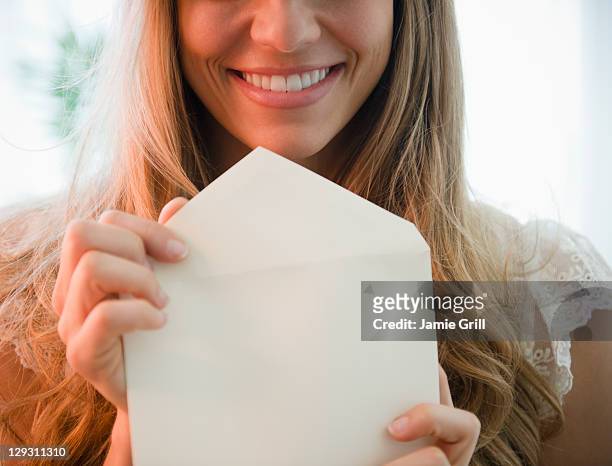 usa, new jersey, jersey city, portrait of blonde woman holding envelope - love letter stock pictures, royalty-free photos & images