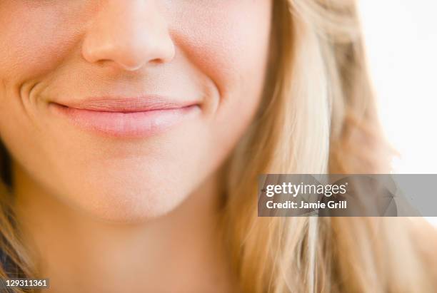 usa, new jersey, jersey city, close up of mouth of smirking woman - sonrisa satisfecha fotografías e imágenes de stock