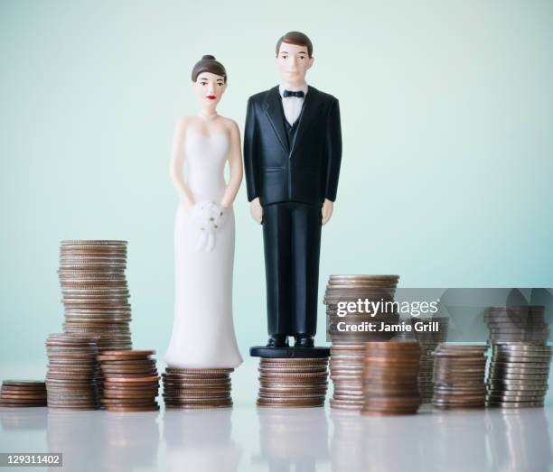 close up of wedding cake figurines on stacks of coins - figurine photos et images de collection
