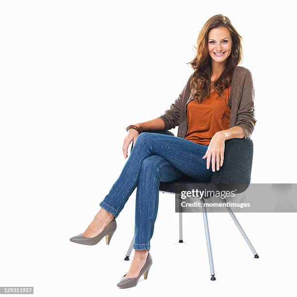 studio shot of young woman sitting in chair - pernas cruzadas imagens e fotografias de stock