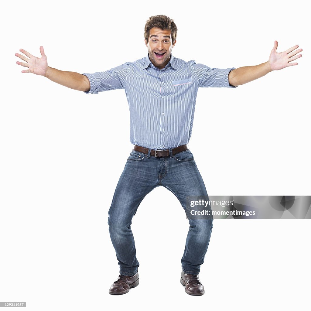 Studio shot of young cheerful man with arms outstretched