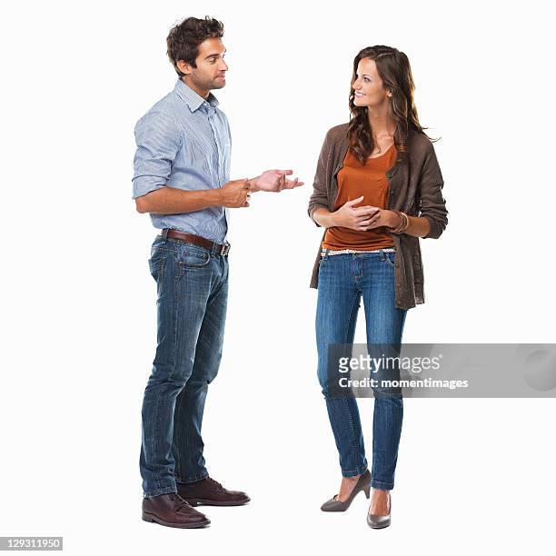 studio shot of young couple having conversation - man standing talking stockfoto's en -beelden