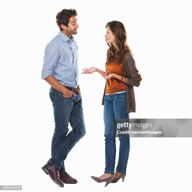 studio shot of young couple having discussion - man standing talking stock-fotos und bilder