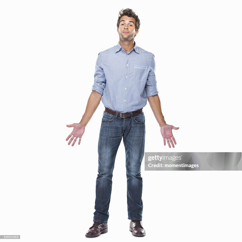 Studio shot of young man with chin up and palms out standing on white background
