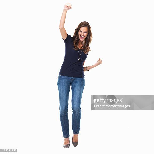 studio shot of young woman celebrating with arm raised - braccia alzate foto e immagini stock