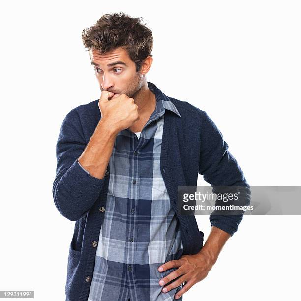 studio shot of young man biting nails and looking away - shy stock pictures, royalty-free photos & images