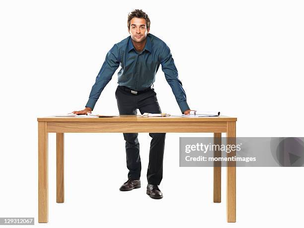 portrait of smart business man standing with palms on table - lean fotografías e imágenes de stock