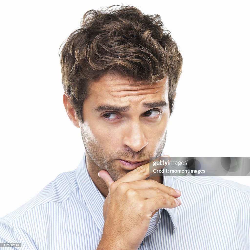 Close-up portrait of confused business man with had on chin against white background