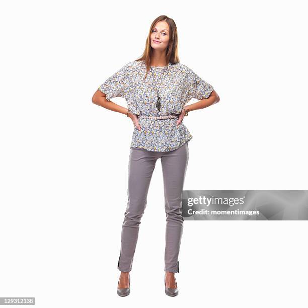 beautiful smiling woman standing with hands on hips against white background - handen op de heupen stockfoto's en -beelden