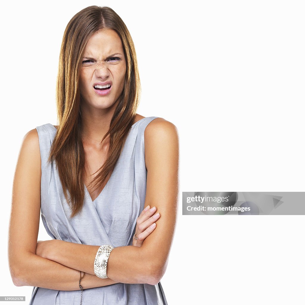 Portrait of young distressed woman standing with hands folded