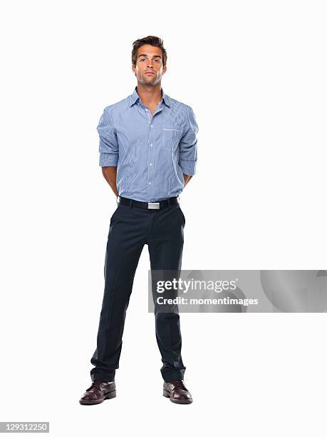 studio shot of young business man standing with hands behind back - hands behind back stock pictures, royalty-free photos & images