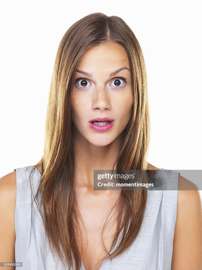 Studio portrait of young surprised woman staring on camera