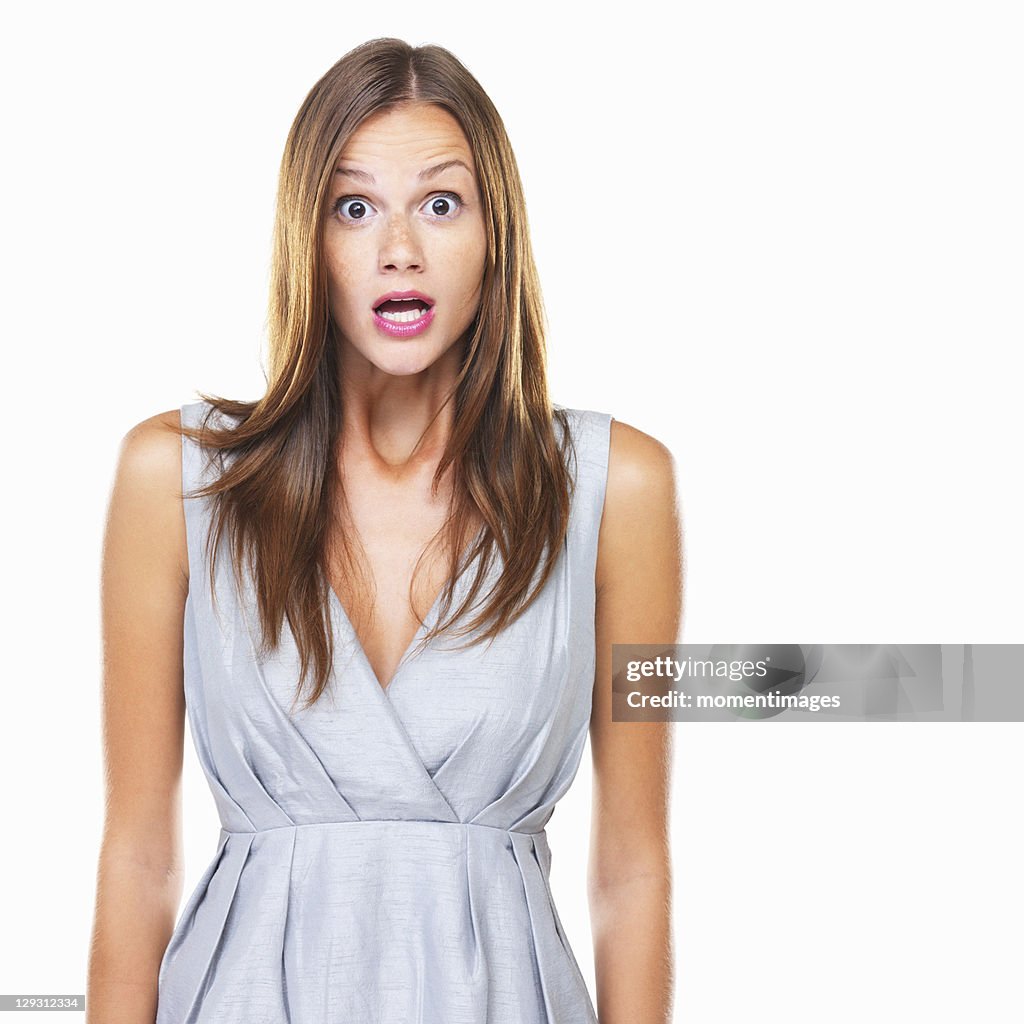 Studio portrait of young surprised woman staring on camera