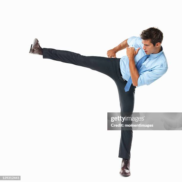 studio shot of business man delivering high side kick - donner un coup de pied photos et images de collection