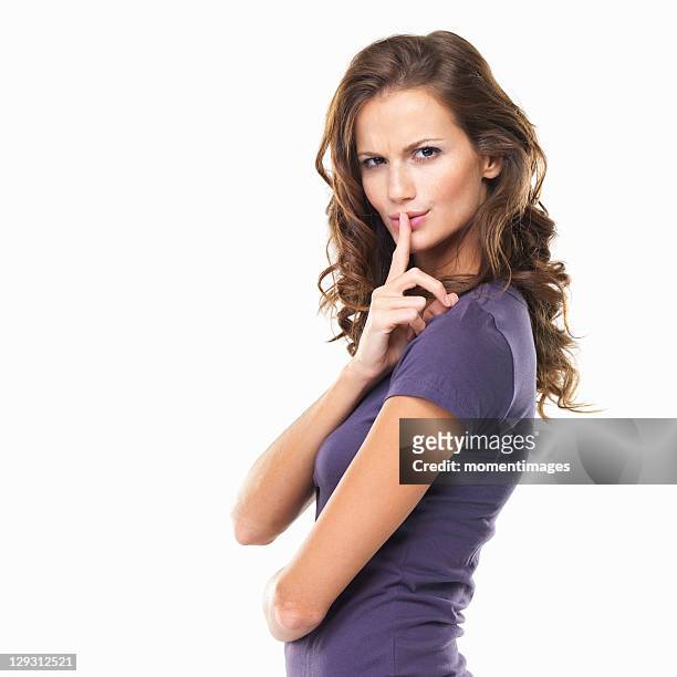 studio portrait of woman with finger on lips - woman hush stock pictures, royalty-free photos & images