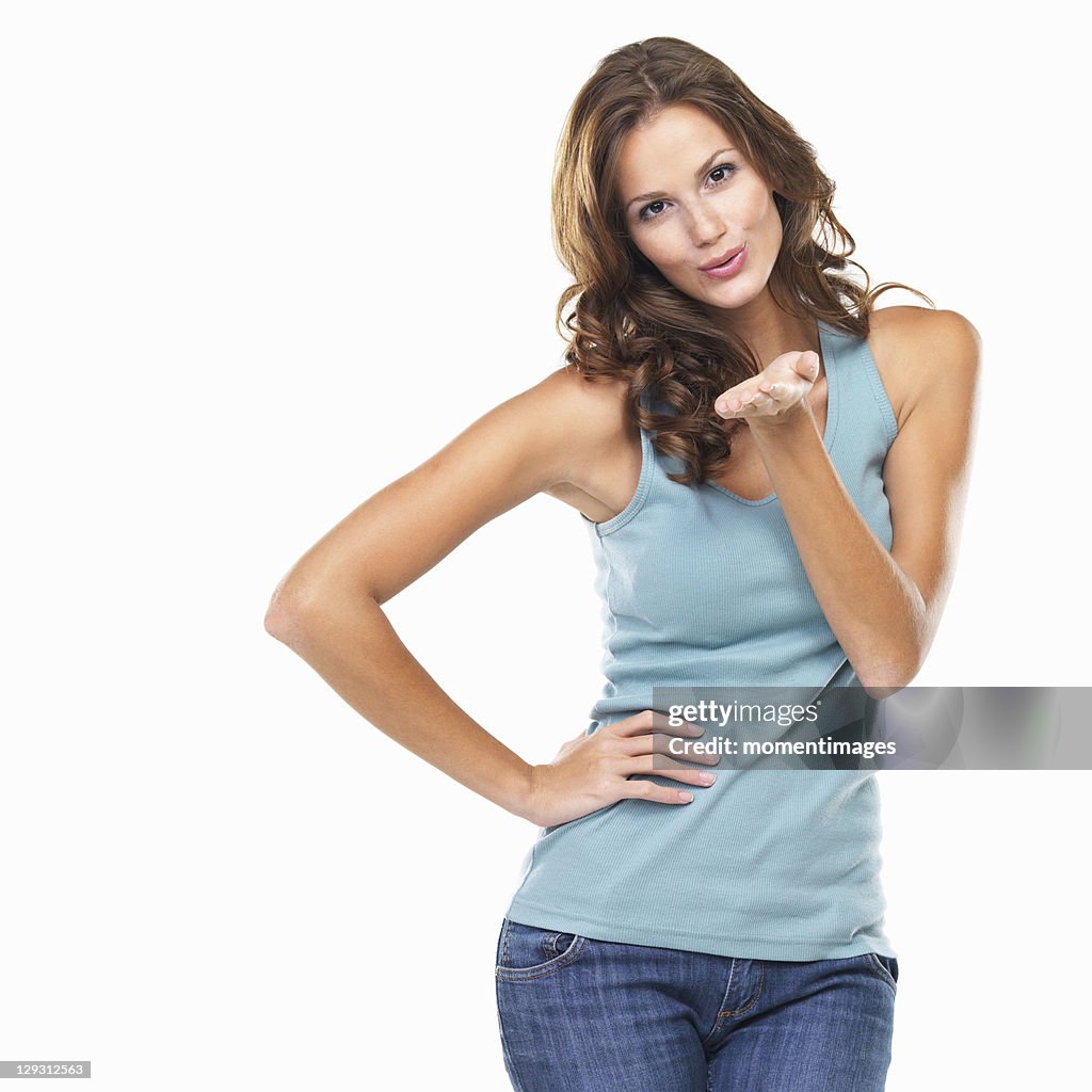 Studio portrait of cute young woman blowing kiss