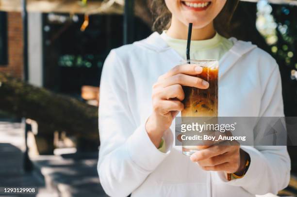 cropped shot of happiness woman holding a glass of iced milk coffee in her hands. - woman ice stock-fotos und bilder