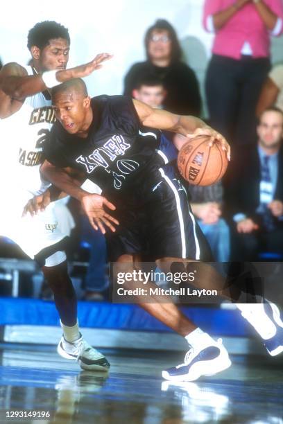 David West of the Xavier Musketeeers of the Xavier Musketeers dribbles the ball during a college basketball game against the George Washington...