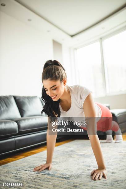 woman doing push ups and exercising at home - press ups stock pictures, royalty-free photos & images