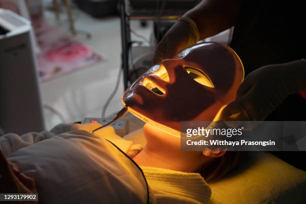 rejuvenating facial light therapy-greenlight slimming beauty machine - facial cleanse stock pictures, royalty-free photos & images