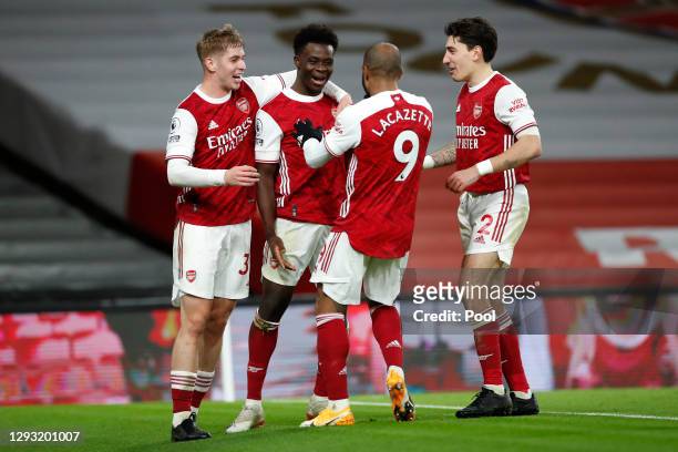 Bukayo Saka of Arsenal celebrates with teammates Emile Smith Rowe, Alexandre Lacazette, and Hector Bellerin after scoring his team's third goal...