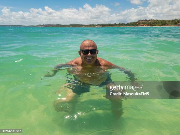 hombre maduro tomando un baño de playa - fat guy on beach fotografías e imágenes de stock