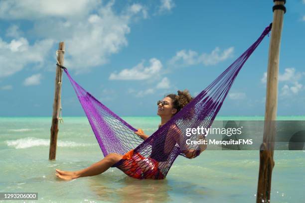 woman relaxing on hammock on beach - swaying stock pictures, royalty-free photos & images