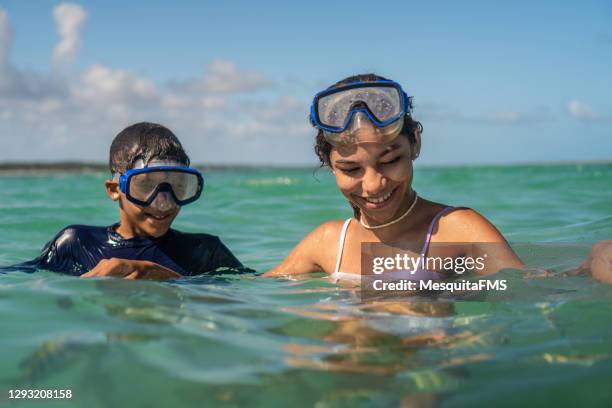 children having fun with fish shoal on tropical beach - scuba diving girl stock pictures, royalty-free photos & images