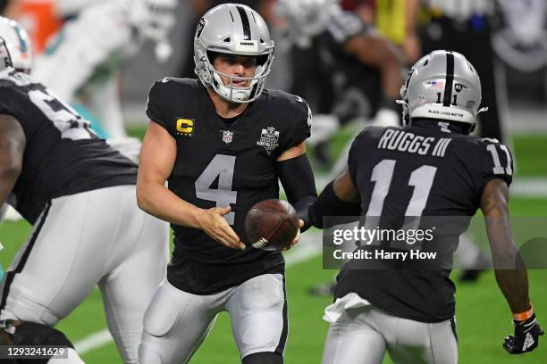 Derek Carr hands the ball to Henry Ruggs III of the Las Vegas Raiders during the first half against the Miami Dolphins at Allegiant Stadium on...