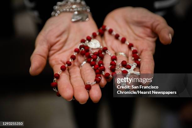 Mariquita Baluyot shows off her rosary after praying with family from all over the world in her daughter Jasmine's home in Redwood City, California...