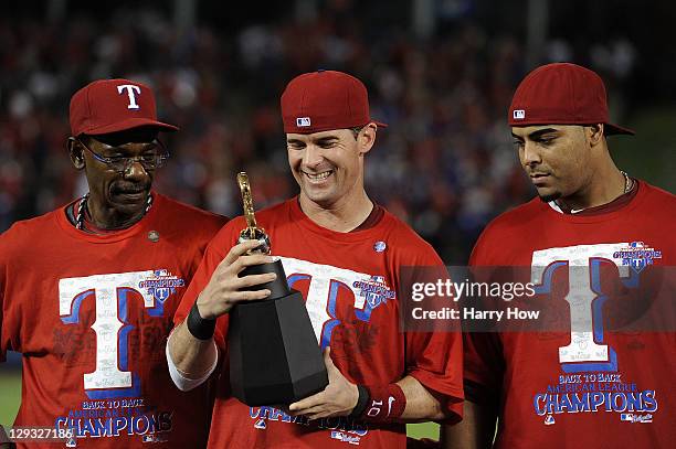 Michael Young of the Texas Rangers holds the William Harridge Award trophy on stage with manager Ron Washington and Nelson Cruz after defeating the...