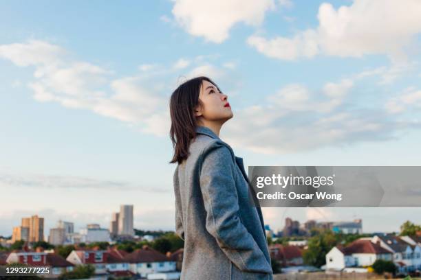 young woman planning for the future - japanese woman looking up stock-fotos und bilder