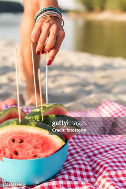 a refreshing slice of watermelon during a summer beach party - watermelon picnic stock pictures, royalty-free photos & images