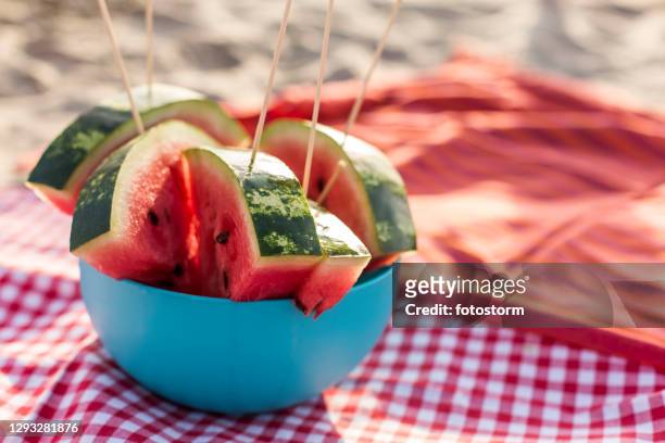 close up of delicious, juicy watermelons in a bowl on a beach picnic - watermelon picnic stock pictures, royalty-free photos & images