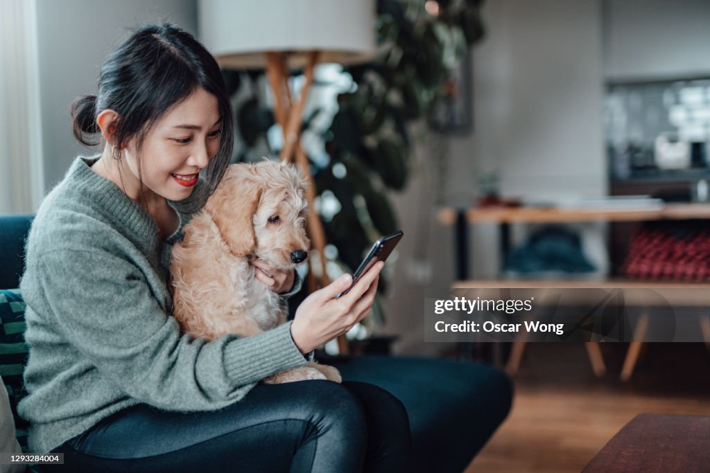Young Woman Taking Selfie With Her Dog With Smartphone