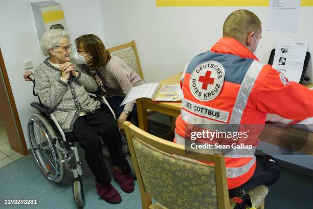 Resident Elfriede Seefeld receives comfort from her daughter, Baerbel Seefeld, before Elfriede was inoculated with the Pfizer/BioNTech vaccine at a...